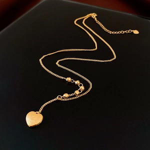 Vista dettagliata di una collana a cuore placcata oro 18K con finitura spazzolata e perle