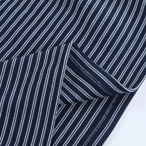 Macro detail of navy and white striped knit fabric showing high-quality stitching