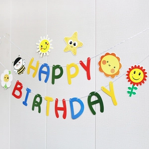 Colorful Happy Birthday banner with daisy, sun, and bee patterns on a beige wall background
