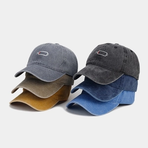 Detailed pile of six washed cotton baseball caps with 1% battery embroidery in various colors