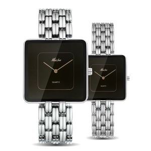 Macro shot of gold-tone square watches with black dials and metallic chain link bracelets