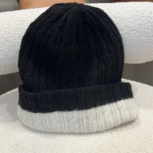 Close-up of chunky knit texture and two-tone black and white design on winter beanie