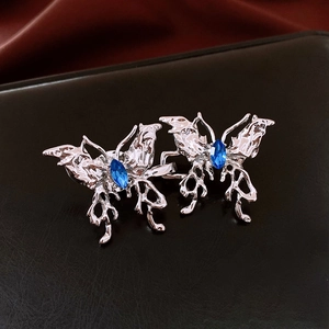Détail de boucles de taille papillon argentées avec pierres bleues sur cuir noir
