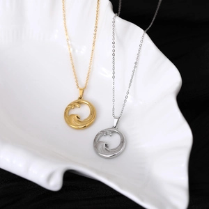 Minimalist stainless steel wave pendant necklaces in gold and silver finish on shell tray