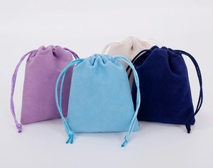 Four colorful drawstring velvet pouches in purple, light blue, dark blue, and beige colors