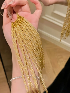 Detail of gold glitter braided bracelets with metallic clasp and pearl bracelet accent