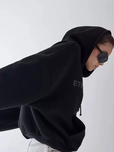 Side view of oversized black hoodie featuring ETR chest print and thick streetwear fabric