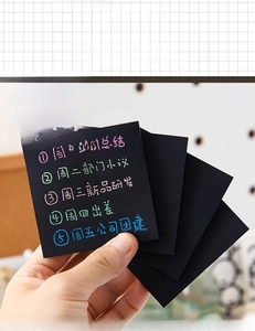 Primo piano di post-it neri con scritte metalliche colorate per la pianificazione