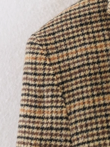 Nahaufnahme der Schulternaht und Hahnentritt-Tweed-Textur an diesem braunen Blazer