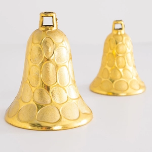 Two golden Christmas bell ornaments with textured finish on white background