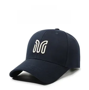 Detail of navy blue baseball cap with white embroidered M letter logo.
