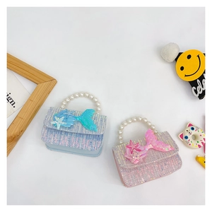 Detail of tweed kids handbags with faux pearl handles and glittery marine sequin appliques
