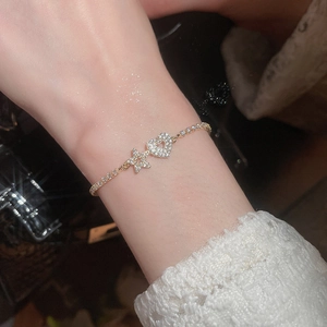Close-up of gold plated heart and star bracelet with sparkling cubic zirconia on wrist