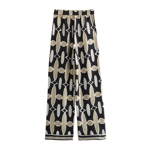 Detail einer Satin-Hose mit weitem Bein, schwarz-weißem Geometrie-Print und Gummibund
