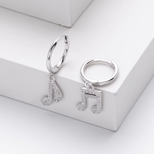 Close-up of silver musical note earrings featuring pavé-set shimmering cubic zirconia