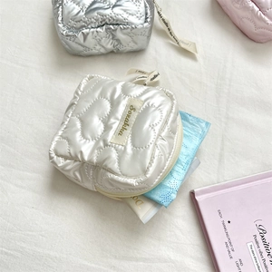 Close-up of quilted heart mini pouch showing storage capacity for personal hygiene items