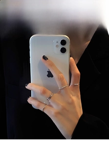 Close-up of minimalist silver rings set with pearls shown on hand in a stylish scene