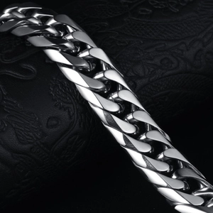 Macro close-up of polished silver stainless steel Cuban chain link showing metallic luster