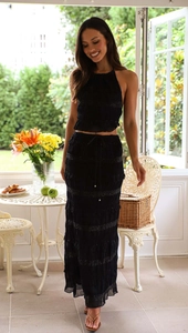 Close-up of black two-piece set featuring pleated metallic fabric and halter neck detail