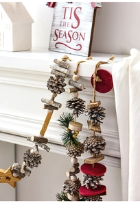 Handcrafted Christmas ornaments with pinecones and wooden stars on a white fireplace