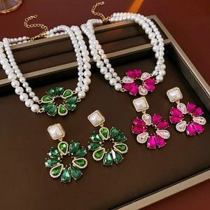 Dettaglio parure floreale con collana di perle multistrato e orecchini abbinati