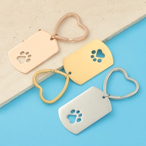 Macro shot of stainless steel dog tag keychains with hollow paw prints in three colors