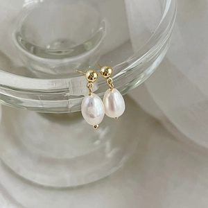 Baroque freshwater pearl earrings with 925 silver needles on a glass rim