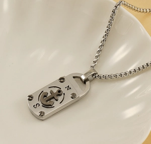 Vue macro d'un collier en acier titane argenté avec pendentif ancre rétro et symboles N/S