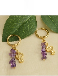 Detail of 18k gold plated hoop earrings with irregular purple natural stones on fabric