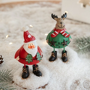 Hand-painted metal Santa and reindeer Christmas table ornaments in snowy scenery