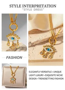 Detailed close-up of evil eye pendant on gold stainless steel chain with droplet tassels