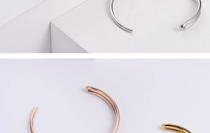 Close-up of minimalist knot bangles in silver, rose gold and gold on marble base