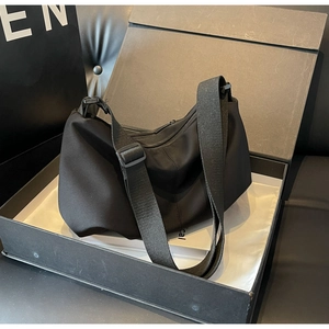 Detailed view of black nylon tote bag in premium packaging box with adjustable strap