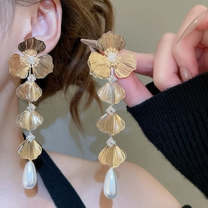 Detail of 18K gold-plated floral earrings with crystal centers and waterdrop pearls