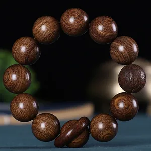 Détail macro de perles en bois Jin Si Tan avec grain doré et gravure de chance