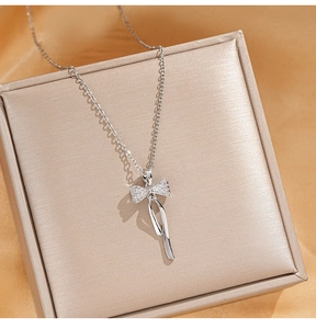 Détail d'un collier pendentif nœud scintillant avec zircons sur un coffret luxe