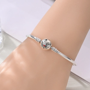 Detail of silver S925 charm bracelet with spider web and heart pattern on a spherical bead