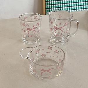 Ensemble de verres à fleurs français avec roses roses et nœuds sur table beige