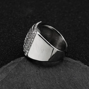 Macro side view of silver stainless steel wide band ring with three rows of white rhinestones