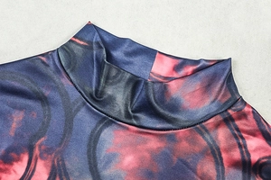 Detailed close-up of a high-neck dress featuring abstract red, black, and blue print pattern