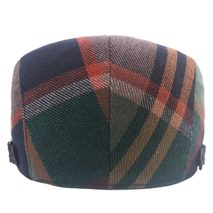 Detail of vintage plaid flat cap featuring side adjustable buckles and green tweed fabric