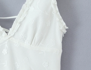 Detail of white mesh lace tank top featuring V-neckline and 3D floral embroidery