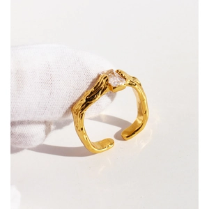 Irregular textured gold open ring featuring a square zircon on a clean white background