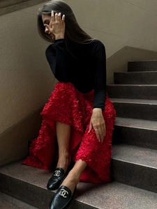 Detail shot of black loafers with double C metal buckle paired with floral skirt