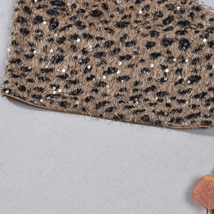 Gros plan d'un haut léopard avec paillettes brillantes et tissu à franges texturé