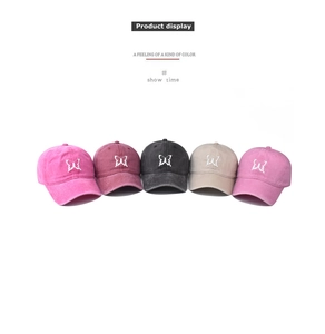 Detail of five washed cotton baseball caps with butterfly embroidery in various colors