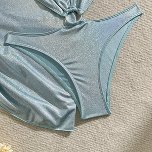 Détail du tissu pailleté bleu clair avec anneau métallique et découpe ajourée