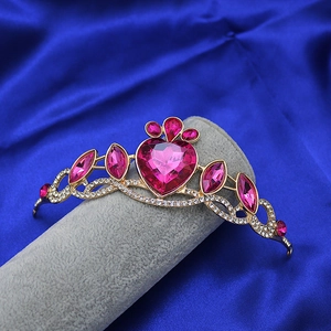 Close-up of golden princess crown with heart-shaped pink gems and sparkling crystals