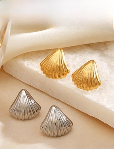 Detailed view of gold and silver shell earrings featuring vertical 3D stripes on silk