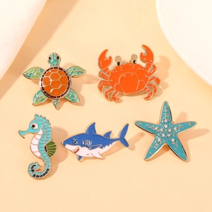 Macro detail of high-quality metal enamel pins featuring sea turtles and ocean creatures